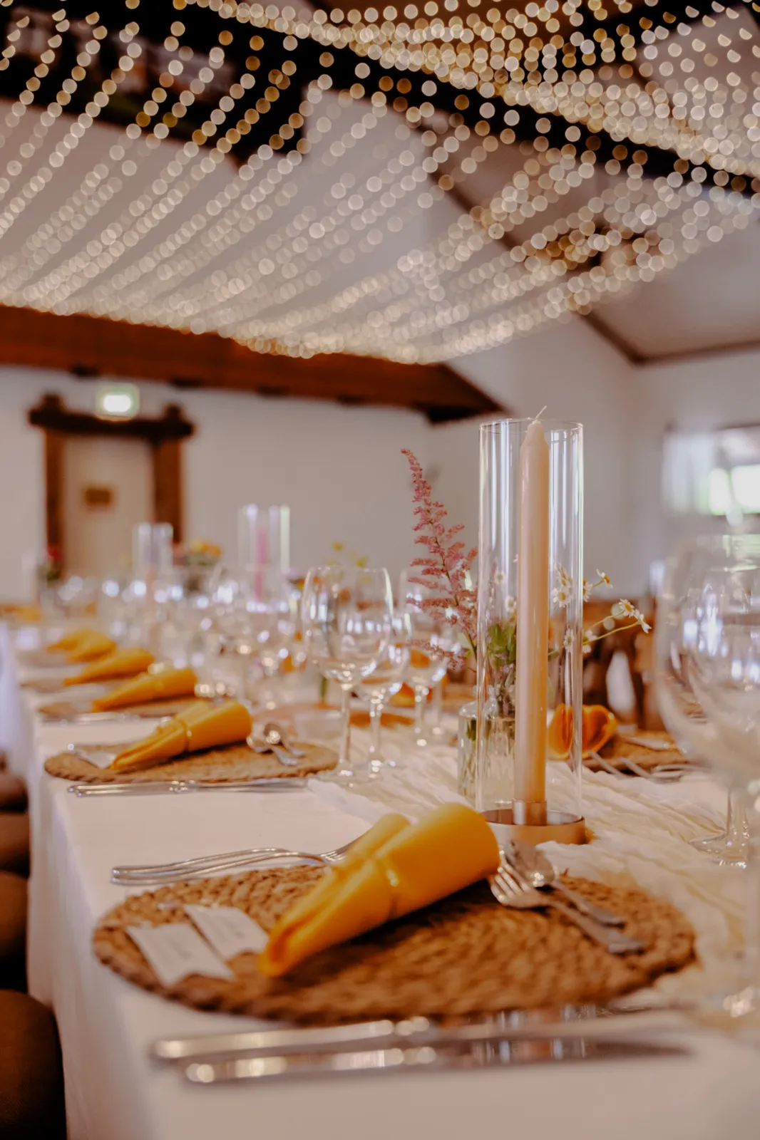 Gedeckter Tisch mit Lichterkette im Hintergrund